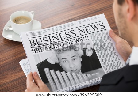 Close-up Of Businessman Reading News In Newspaper