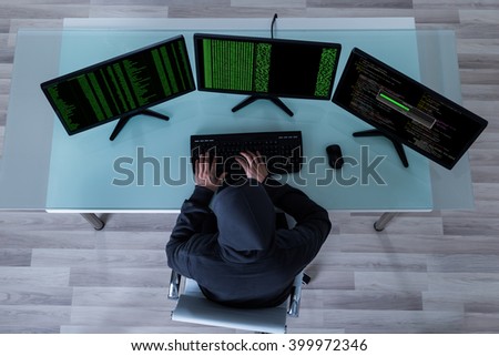 High Angle View Of Hacker Stealing Information From Multiple Computers