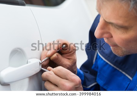 Close-up Of Person Hand Holding Lockpicker To Open Car Door