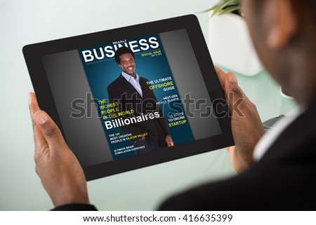 Close-up Of A Young Businesswoman Reading Online Magazine On Digital Tablet