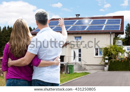 Rear View Of Couple Standing In Front Of Their House
