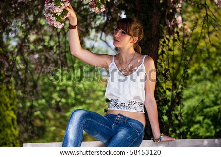 Teenager girl collecting flowers outside during a summer day in the park.