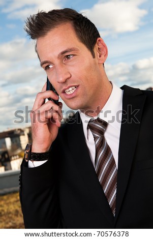 Businessman talking on cellphone outside