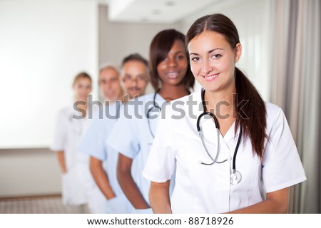 stock photo Mature young female doctor with group of happy successful 