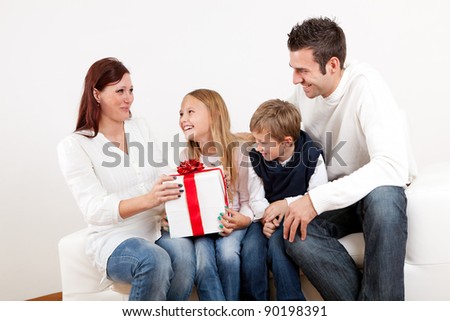 Happy mom receiving a gift from her kids at home