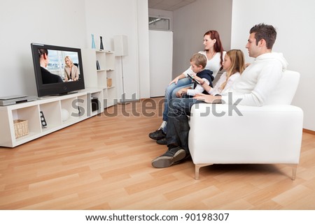 Young family watching TV together at home