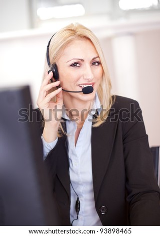 Beautiful call center operator talking over the phone in the office