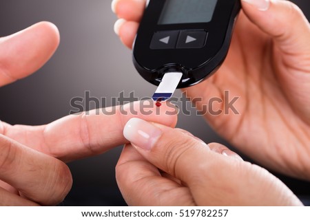Close-up Of A Doctor Checking Patient\'s Sugar Level With Glucometer