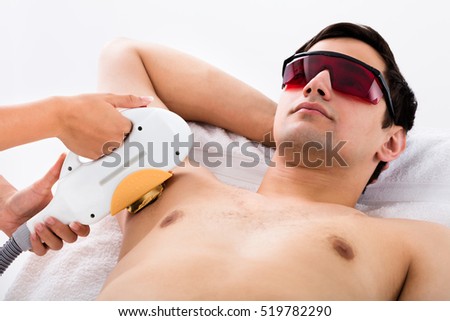Young Man Receiving Laser Epilation Treatment On Underarms In Spa