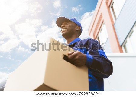 Low Angle View Of Loader Man Standing Near The Van Holding Cardboard Box