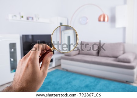Home Property Inspection Concept With Person Holding Magnifying Glass At Home
