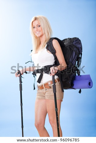 Beautiful young hiking woman with backpack and jogging sticks