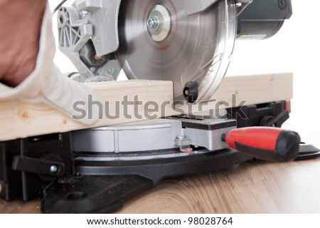 Worker cutting timber using circular electric saw
