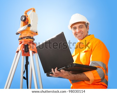 Portrait of Senior land surveyor working with theodolite at construction site
