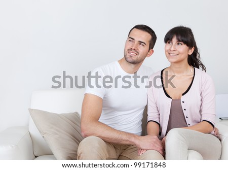 Happy young couple dreaming about the future at home