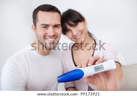 Young couple finding out results of pregnancy test at home