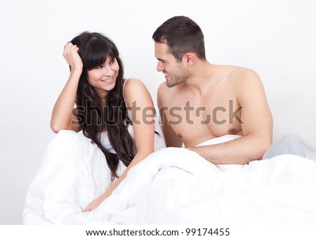 Lovely young couple waking up in bed at home