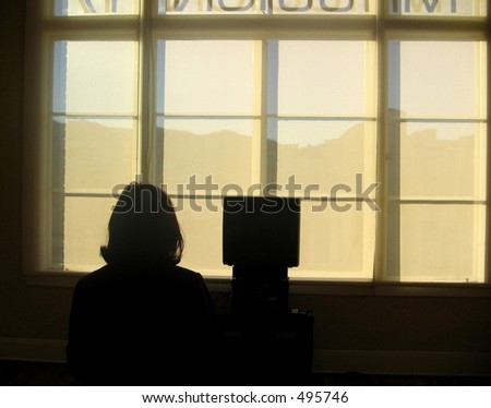 a dark silhouette watches a television in front of a window
