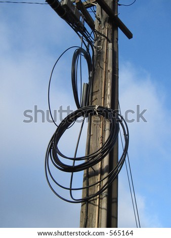 two heavy rolls of cable hanging from a telephone pole