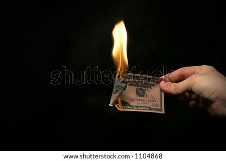 Money To Burn! A hand holding a Fifty Dollar Bill on fire.