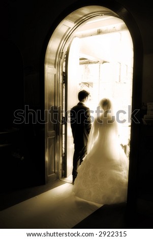 A bride & groom walk toward the church door  - sepia - old style