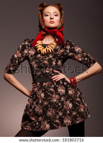 Girl in Russian style posing in red kerchief and bagels on the neck.