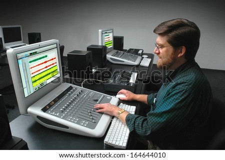 Man working at a digital sound mixing board