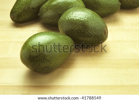 Avocados on a butcher block cutting board
