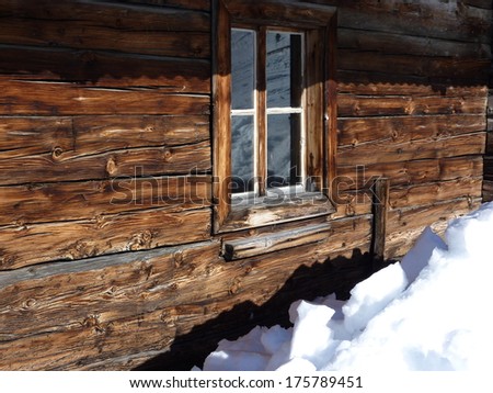 Window in snowy mountain hut