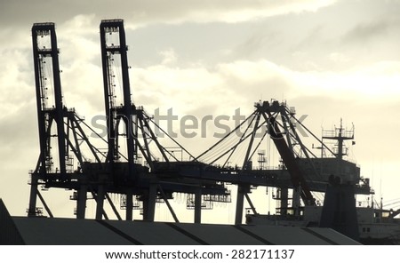 Silhouette of cranes on skyline in port shipping area, Auckland, New Zealand