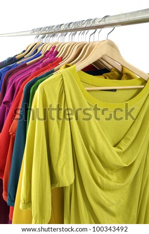 female colorful shirt clothing hanging on hangers
