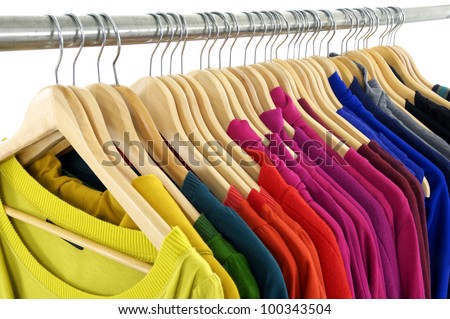 Row of fashion female colorful clothing hanging on hangers