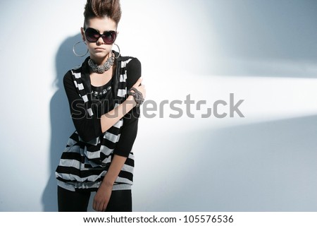 fashion shot of girl with sunglasses posing in light background