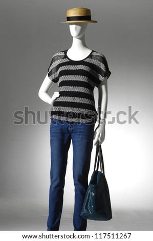 female clothing in jeans with bag on mannequin in light background