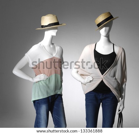 Fashion clothes in jeans on two mannequin holding bag