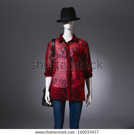 female clothes in hat with bag on a mannequin on light background