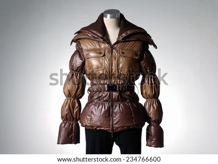 female in coat on mannequin-light background