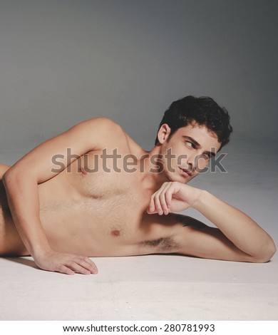 Beautiful (handsome) muscular male model lying down in studio