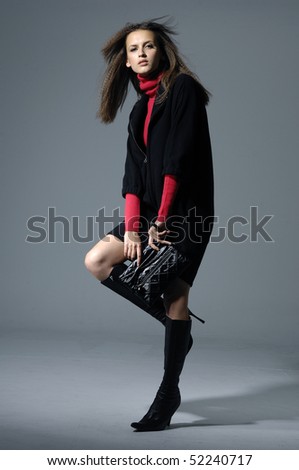 fashion model holding little purse on gray background