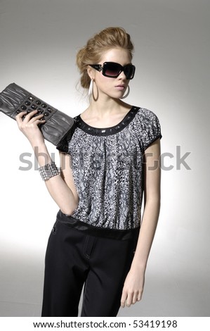 fashion model holding little purse on light background