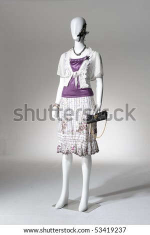 Fashion clothes on a mannequin holding bag posing
