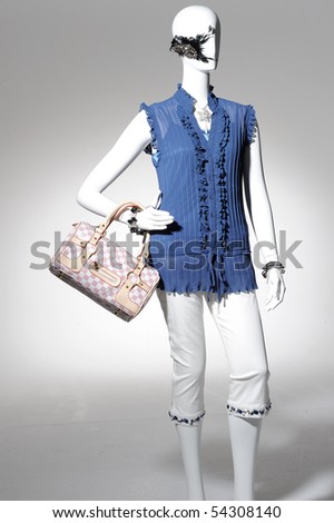 Fashion clothes on a mannequin holding bag posing