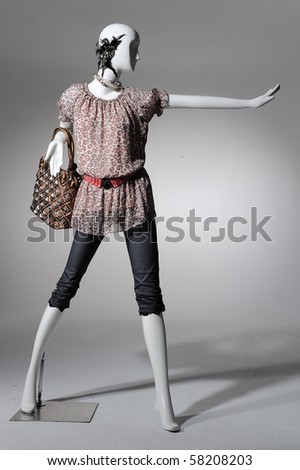 Fashion clothing on mannequin with bag on light background