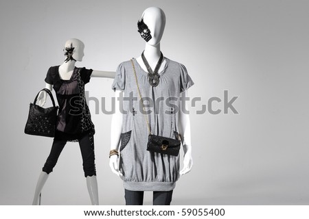 Fashion clothes on a mannequin holding bag on light background