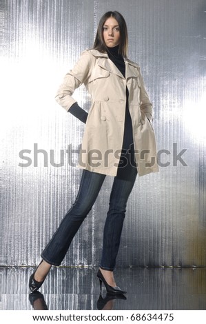 fashion model in coat clothes posing in light background