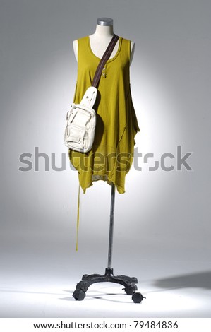 Fashion clothes on a mannequin with bag in light background