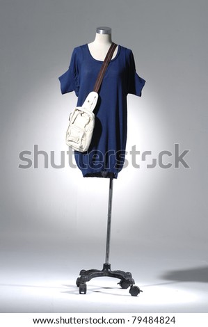 Fashion blue clothes on a mannequin holding bag in light background