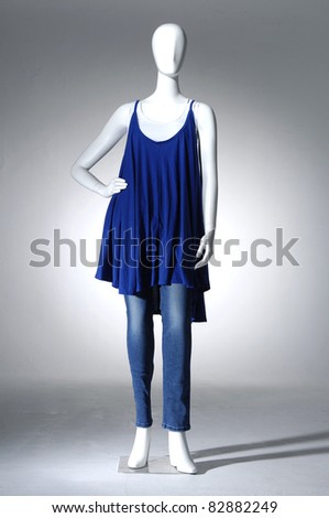 Mannequin dressed in fashion shirt and blue jeans on light background