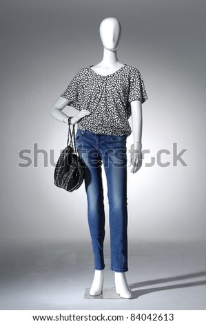 Full length mannequin dressed in jeans with bag,