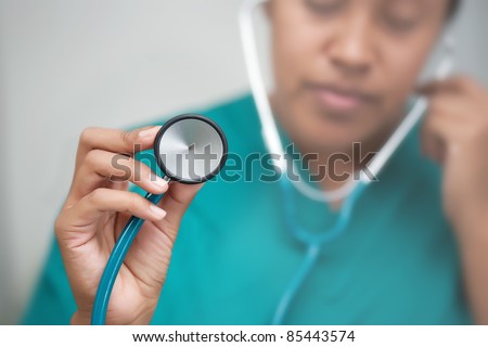 Female doctor with stethoscope in hand listening to heartbeat